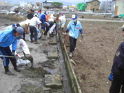 土砂で埋まった側溝の泥出し作業