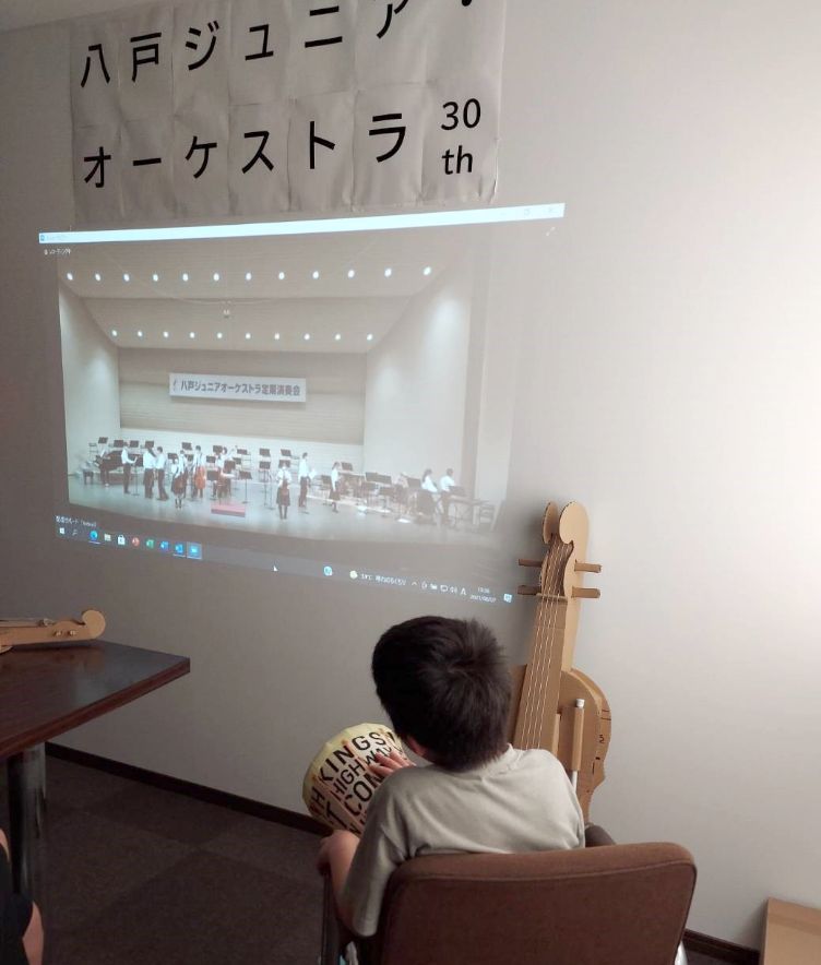 コンサートをオンラインで鑑賞しながら、模擬楽器を弾いている様子。